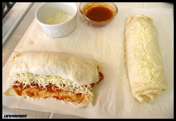 Uncooked pizza roll-ups on parchment paper. 