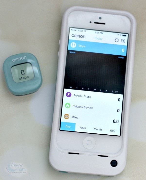 Phone with the Omron app open and next to the device. 