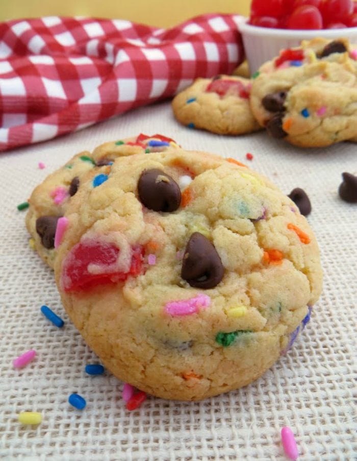 Banana split cookies with chocolate chips and cherries on a table.