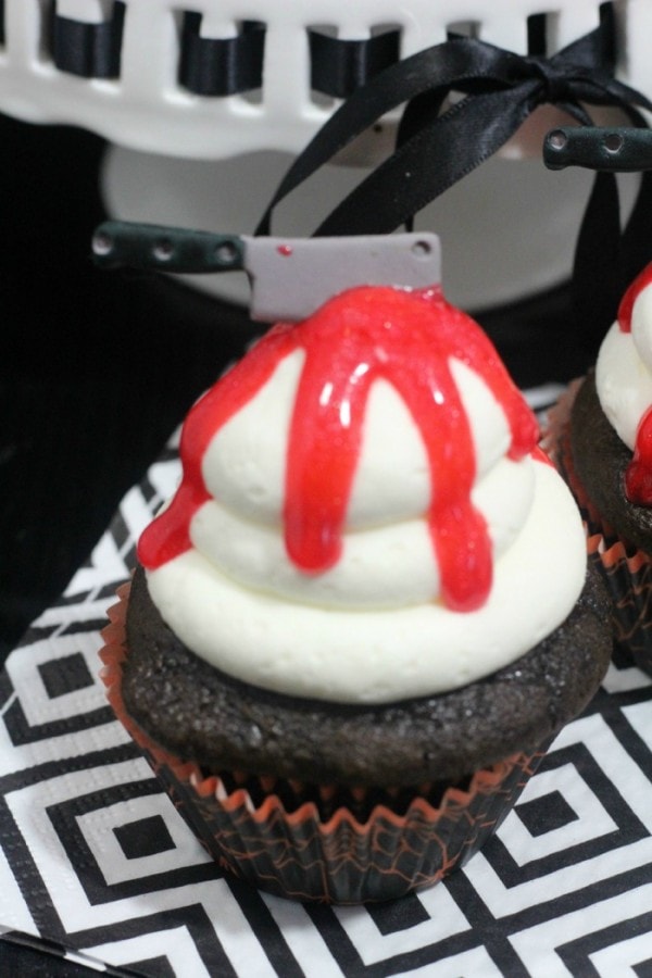 Chocolate cupcake with candy knife and red gel for Halloween.