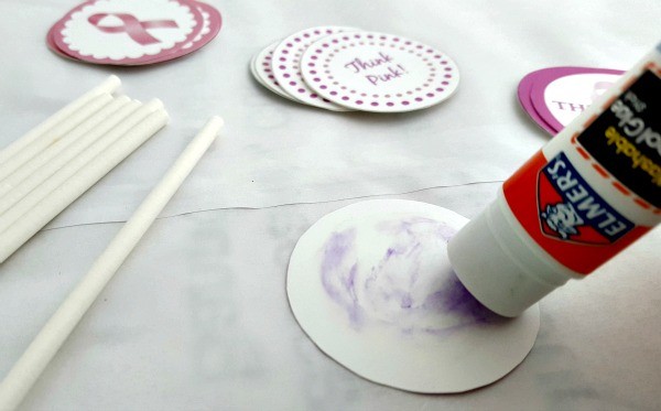 Putting glue on a cupcake topper circle. 