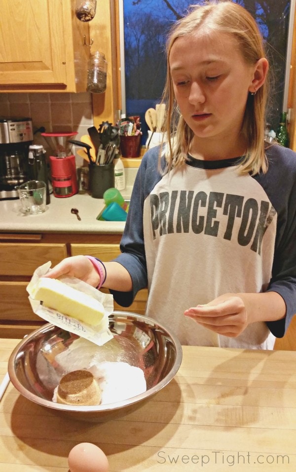 Chesney holding butter over a mixing bowl. 