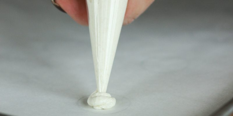 Piping batter onto parchment paper. 