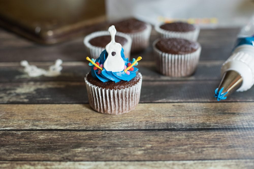 Chocolate cupcake topped with a guitar. 