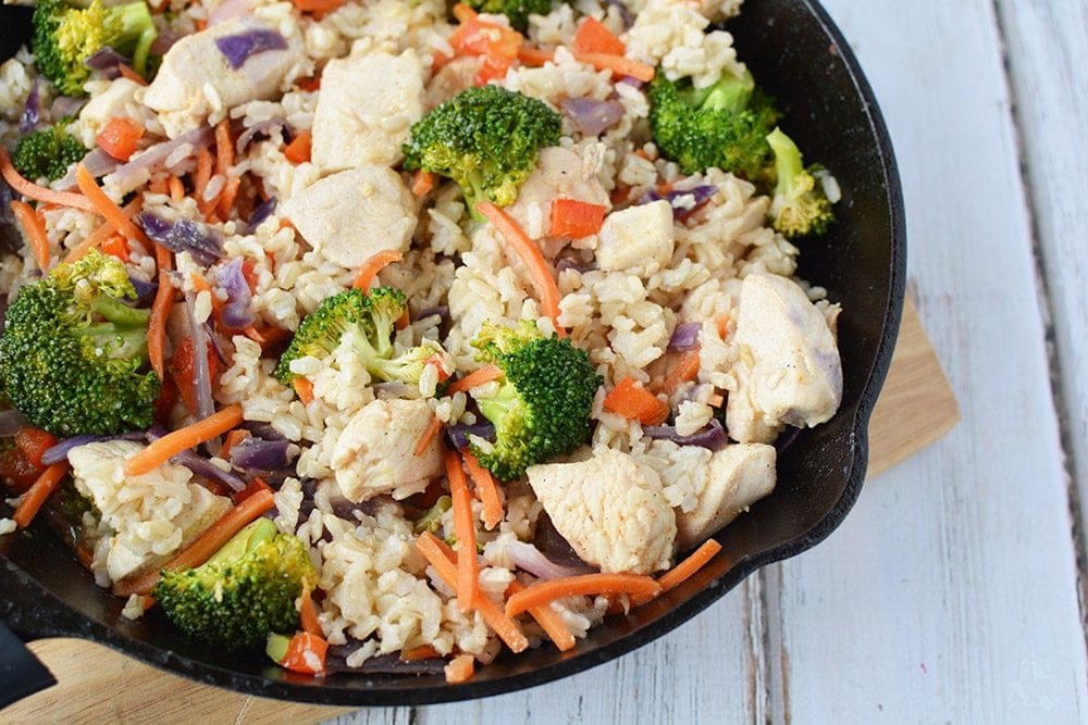 Ginger chicken with veggies and rice in a skillet.