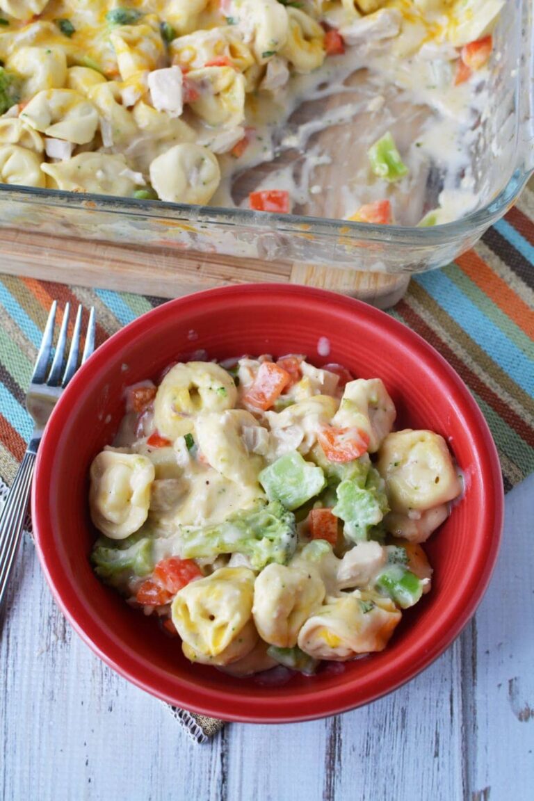 chicken tortellini with cream sauce and veggies in a red bowl
