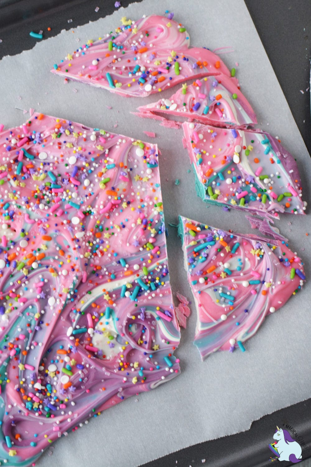 Pink and blue swirly bark candy on a baking sheet.