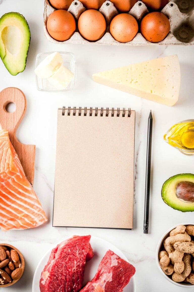 Ketogenic low carbs diet concept. Healthy balanced food with high content of healthy fats. Diet for the heart and blood vessels. Organic ingredients, white background, copy space top view, notepad