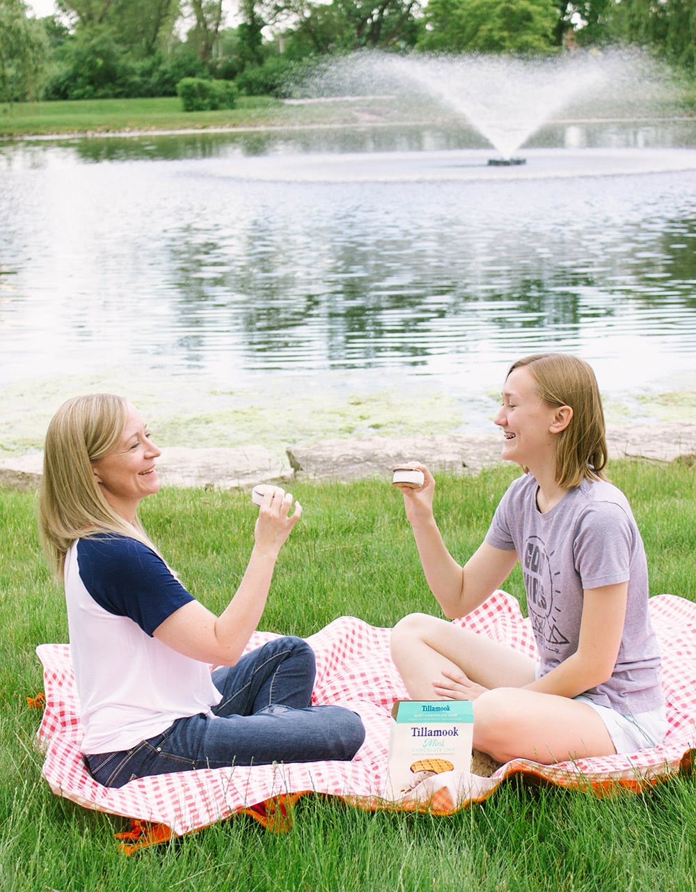 Jennie and Chesney on a picnic blanket in front of water.