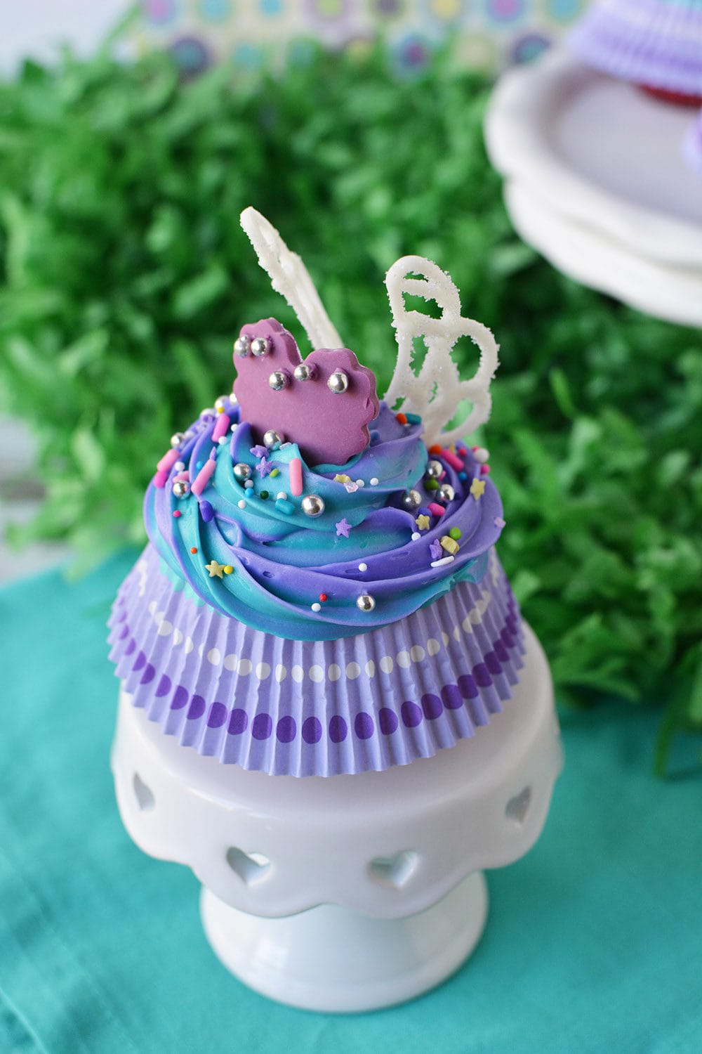 Cupcake on a cake stand with purple heart and wings.