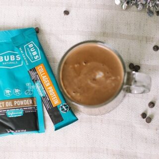 Packets of BUBS next to a mug of keto hot chocolate
