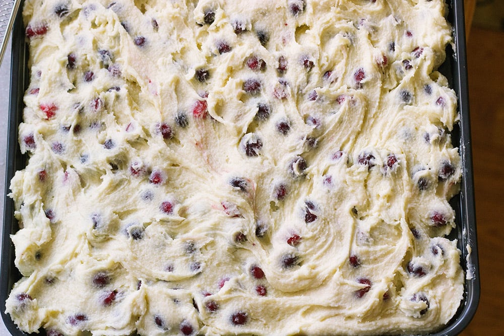 Almond cake with cranberries in a baking sheet.