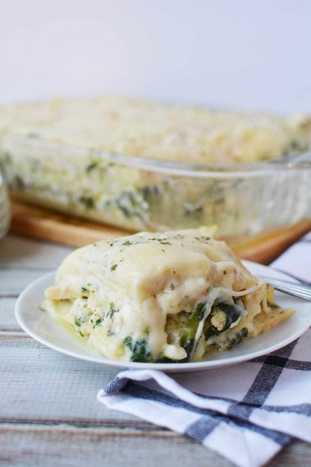 Chicken lasagna with spinach and broccoli sliced on a plate.