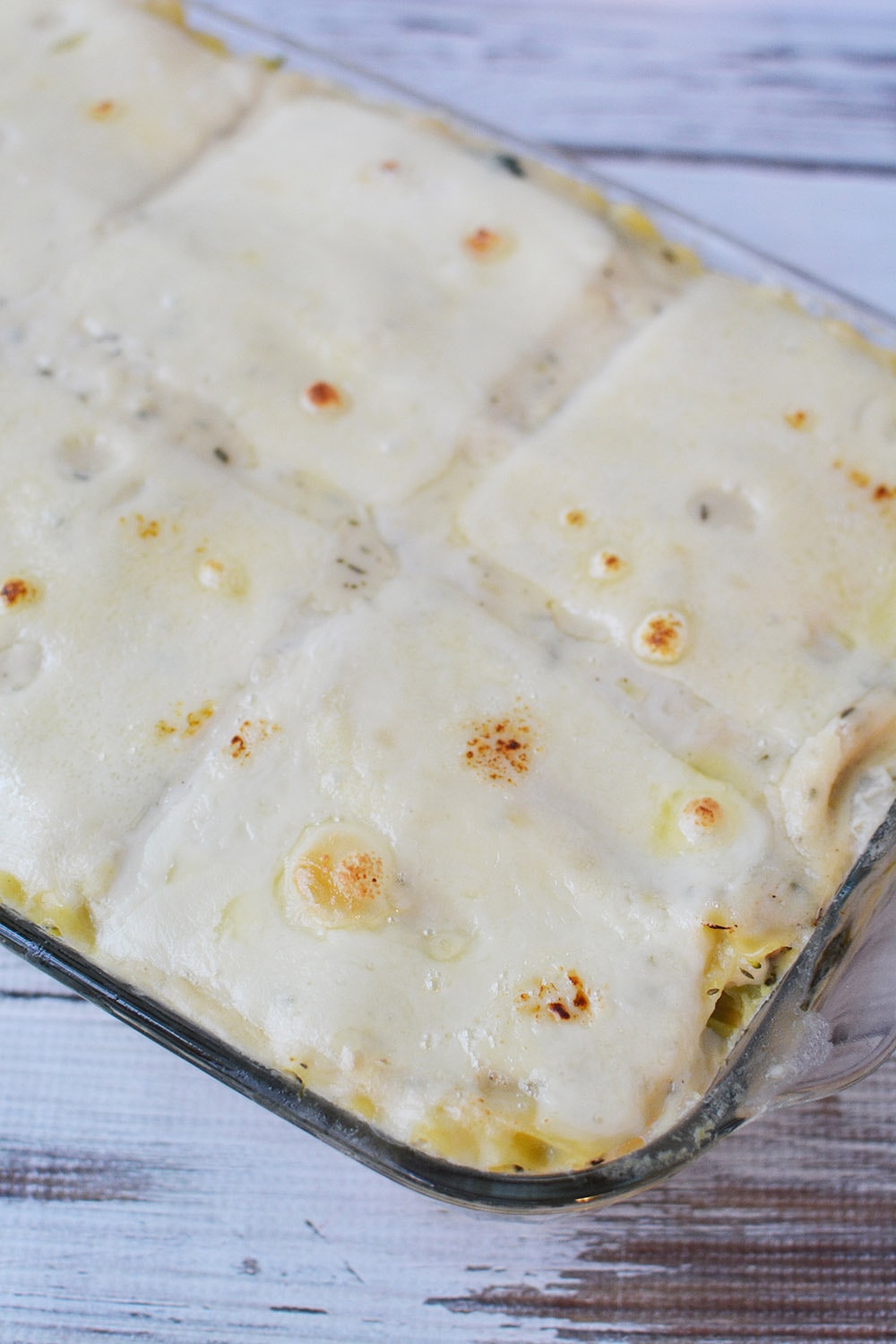 Cheese on top of lasagna in a baking dish. 
