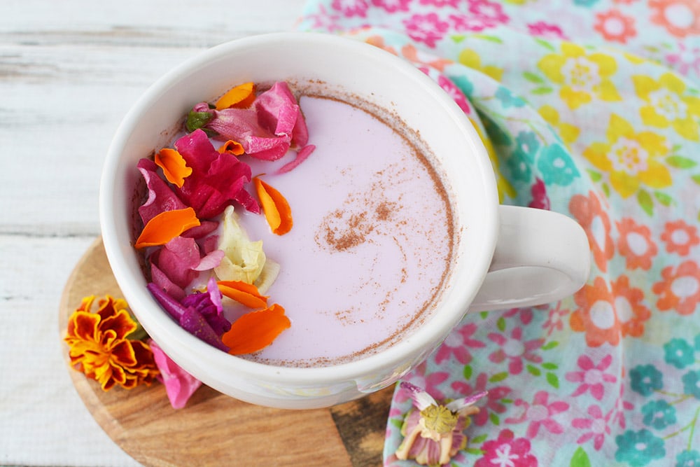 Mug of moon milk with edible flowers on top