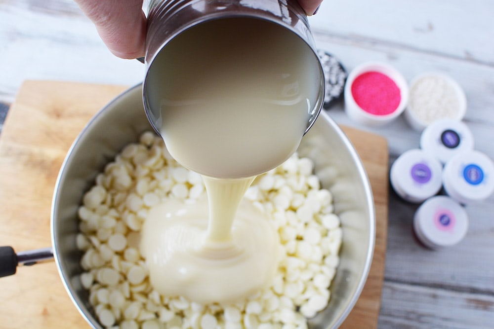 Adding sweetened condensed milk to chips in a sauce pan.