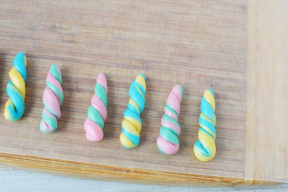 Candy unicorn horns on a board.