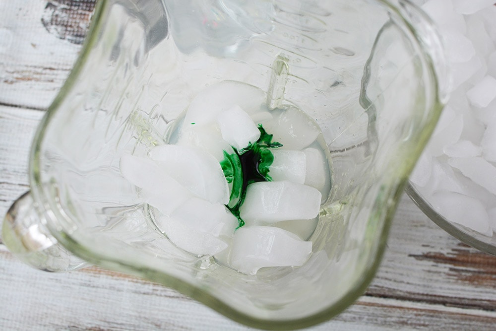 Green food coloring on top of ice in a blender. 