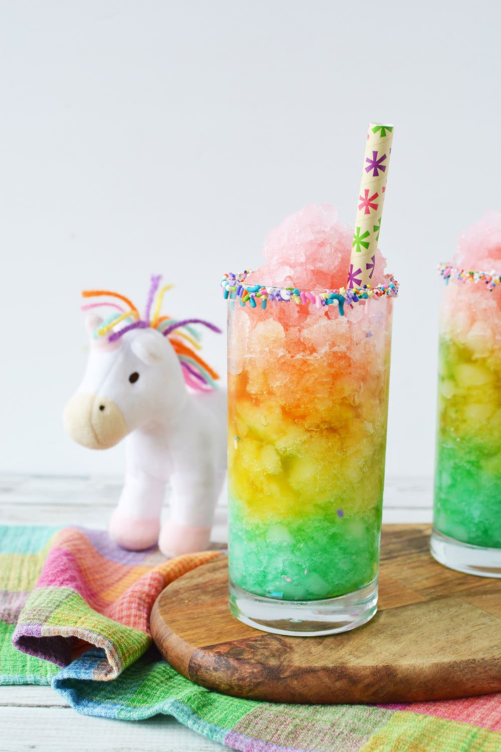 Rainbow slush next to a unicorn plush toy.