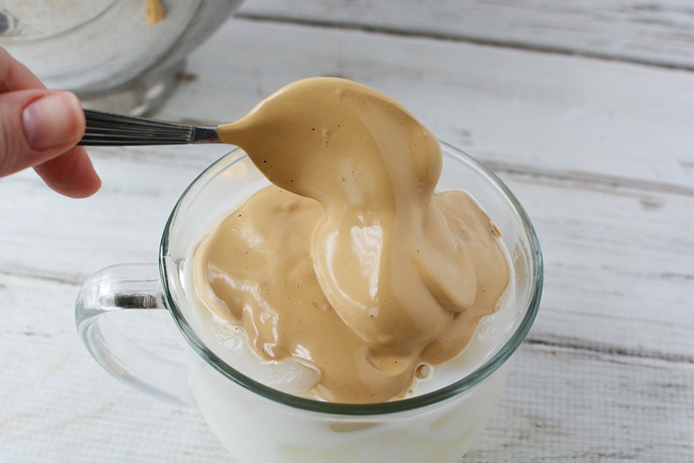 Topping milk and ice with whipped coffee.
