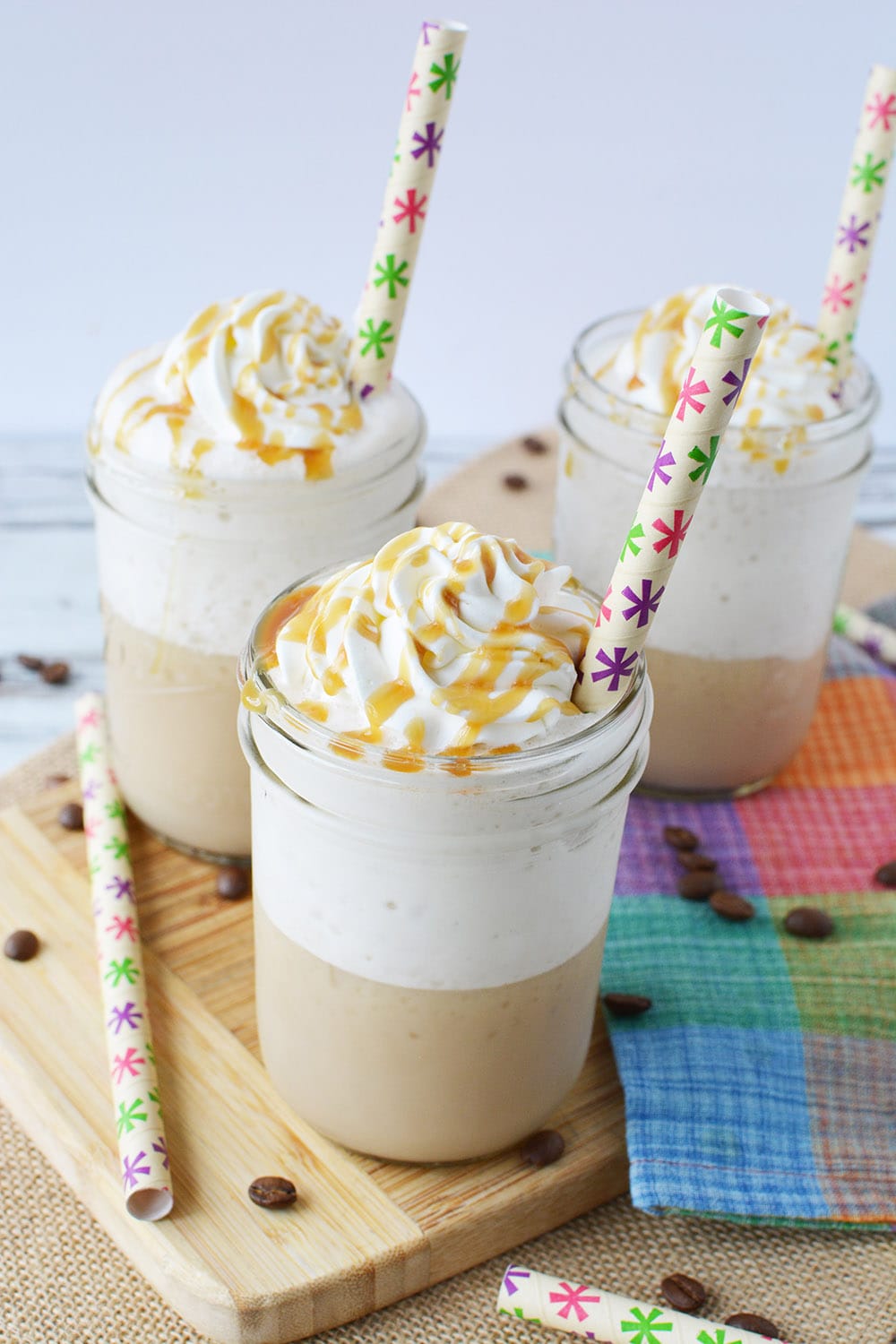 Glasses of caramel frappuccino coffee drinks with colorful straws. 