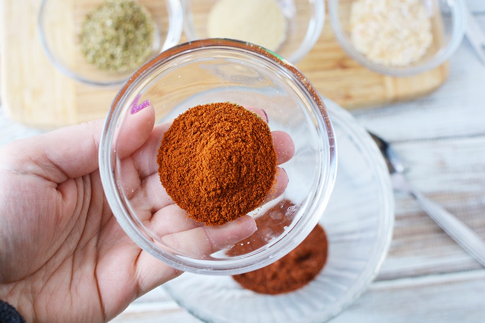 Holding a bowl of spice. 