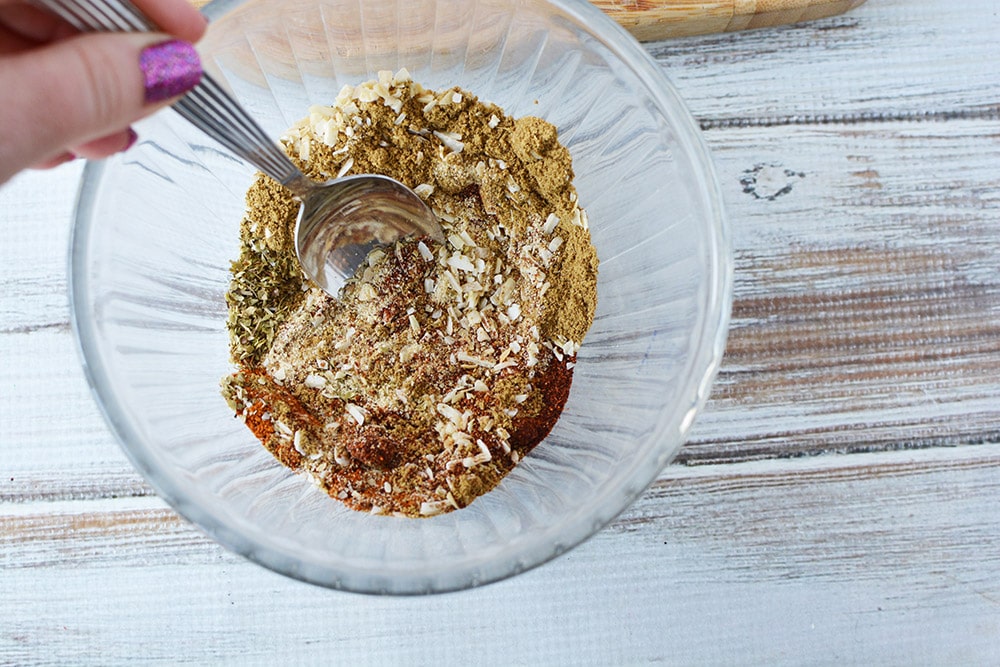 Stirring spices in a bowl with a spoon. 