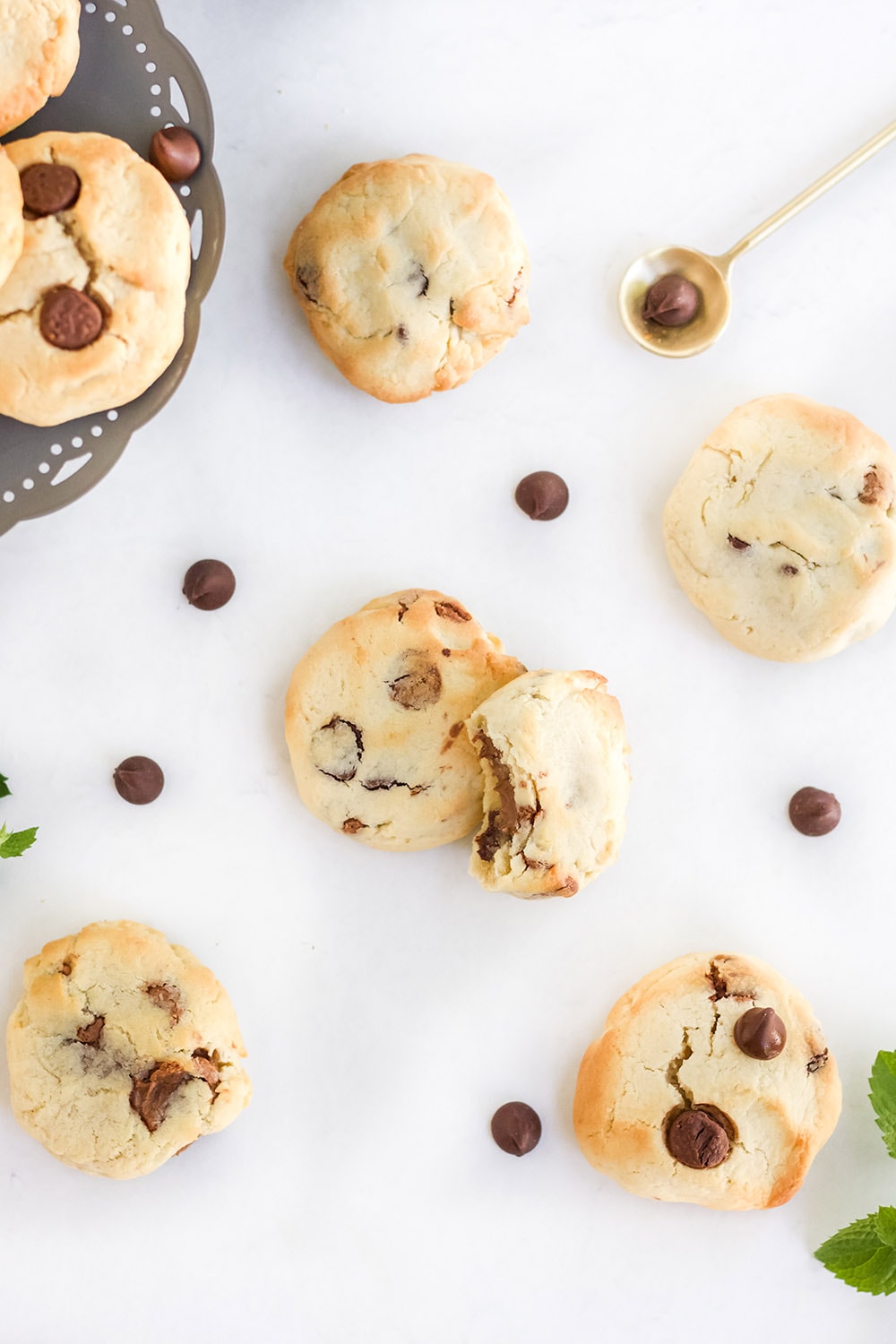 Chocolate chip cookies and chips on a white table.
