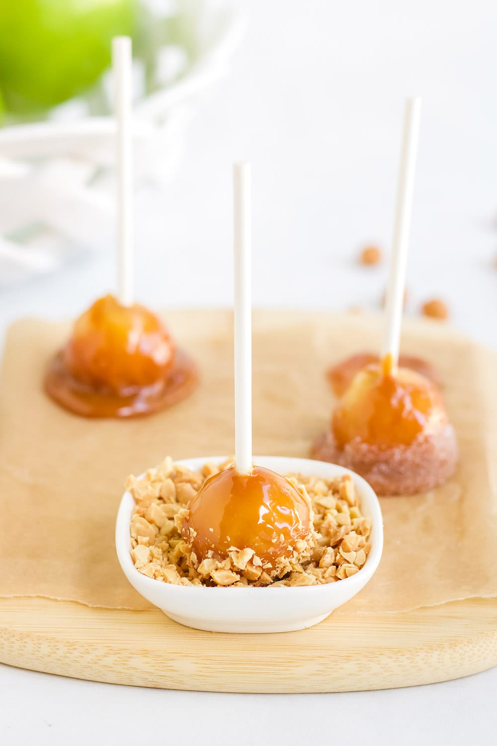 Dipping caramel apple into nuts.