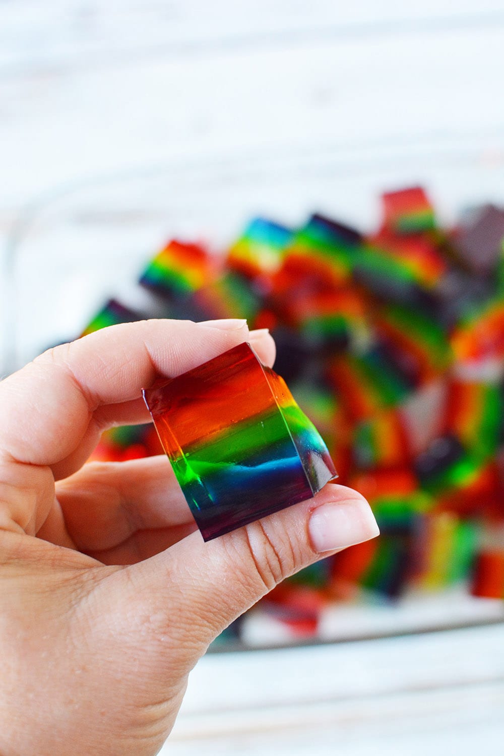 Holding a rainbow jello cube.