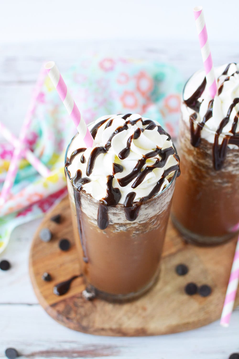 Java chip frappuccino in a glass topped with whipped cream and syrup.