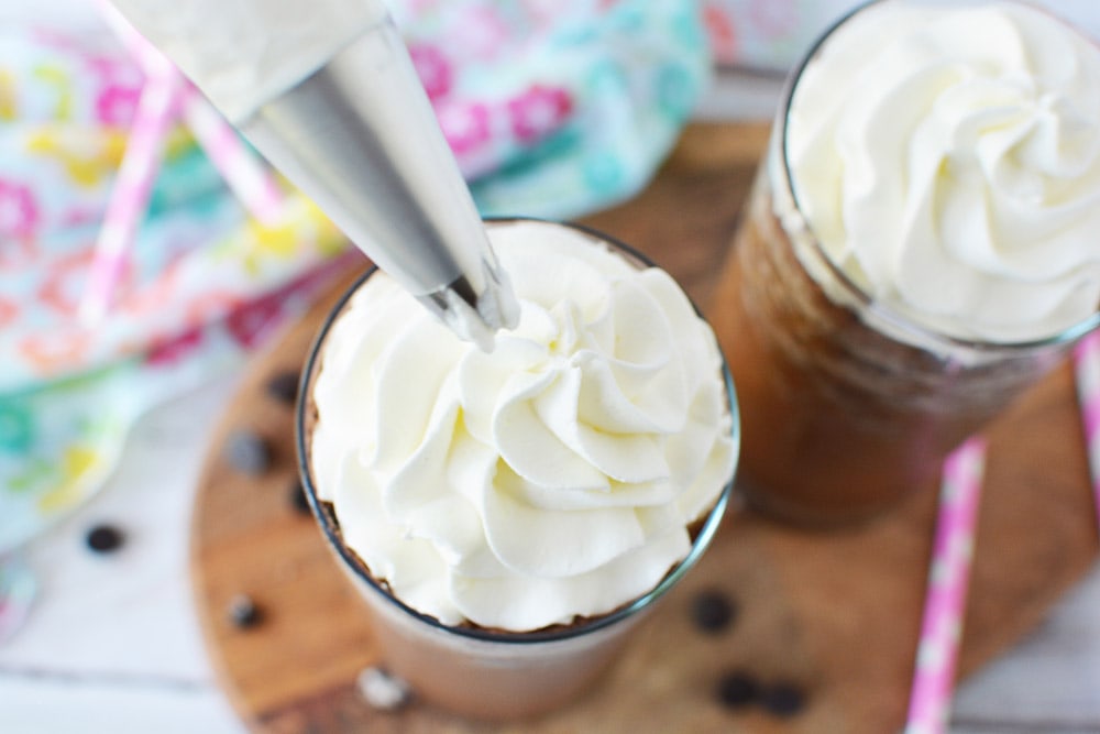 Whipped cream on top of java chip frappuccino in glass.