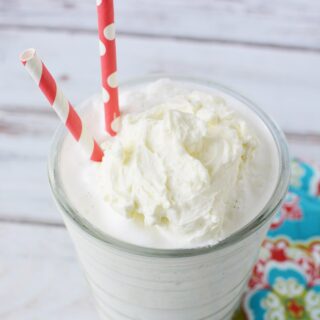blended vanilla bean frappe in a glass with two red straws