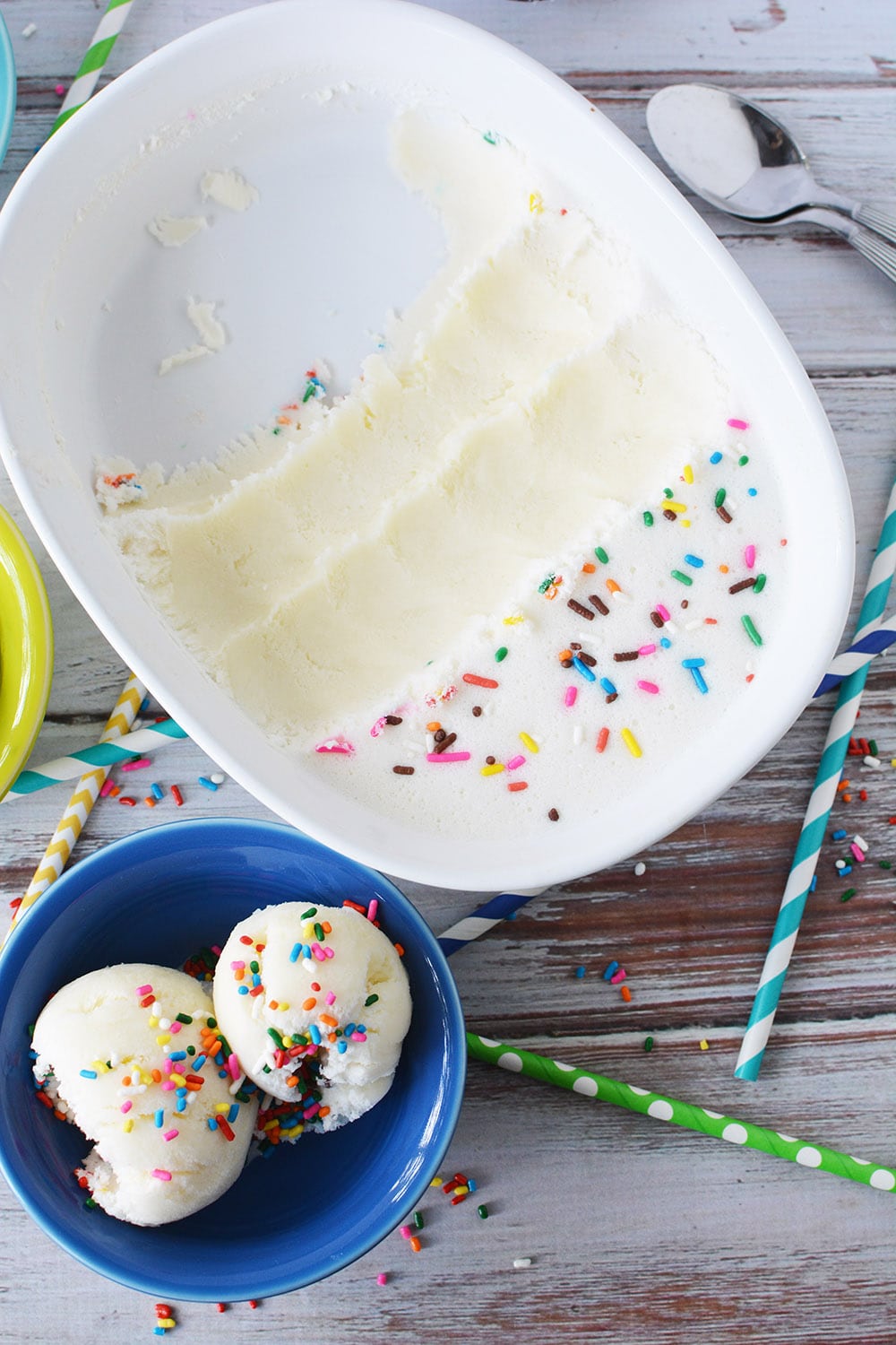 Ice cream scooped out of dish and into a blue bowl.