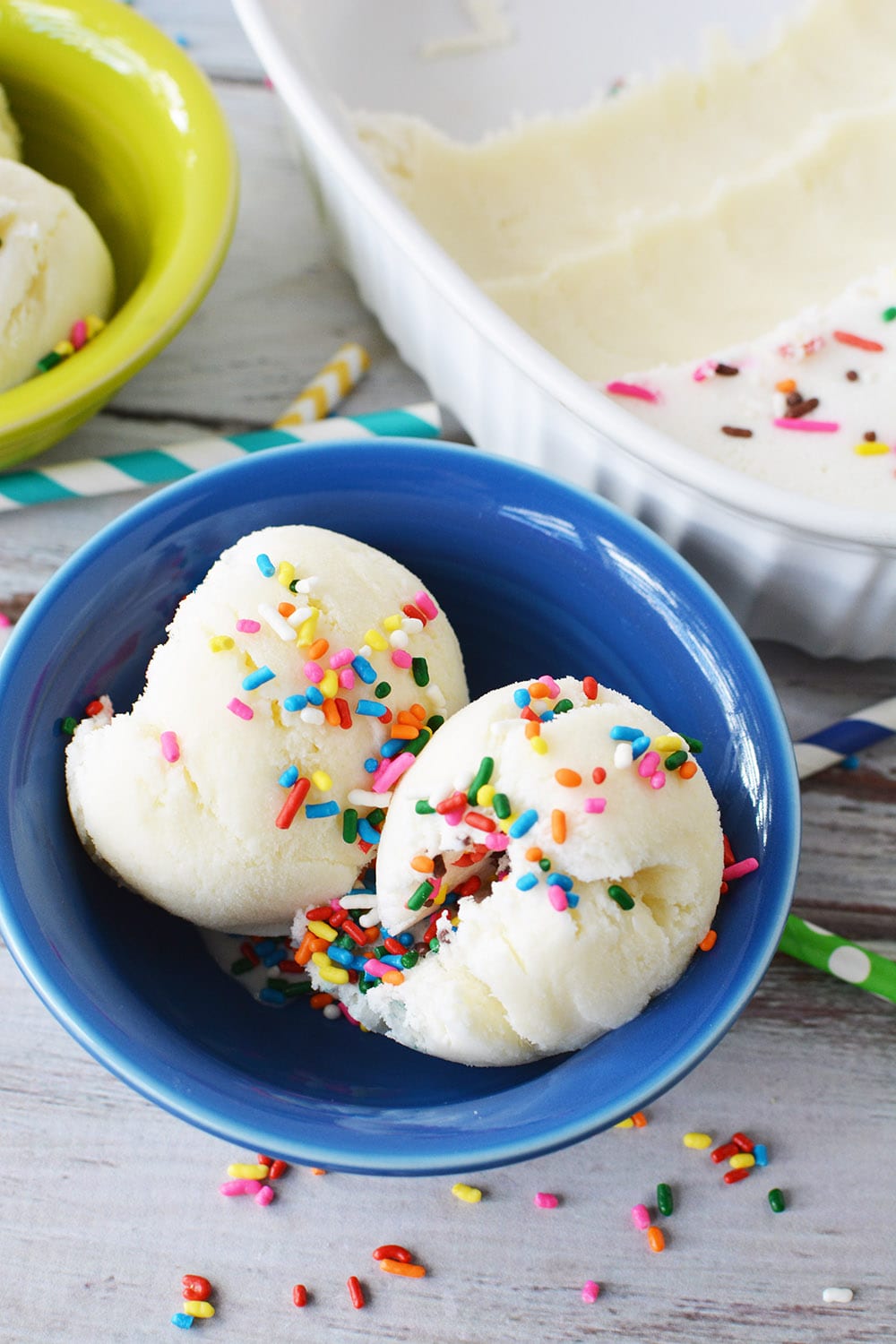 birthday ice cream scoops in a blue bowl topped with rainbow jimmies.