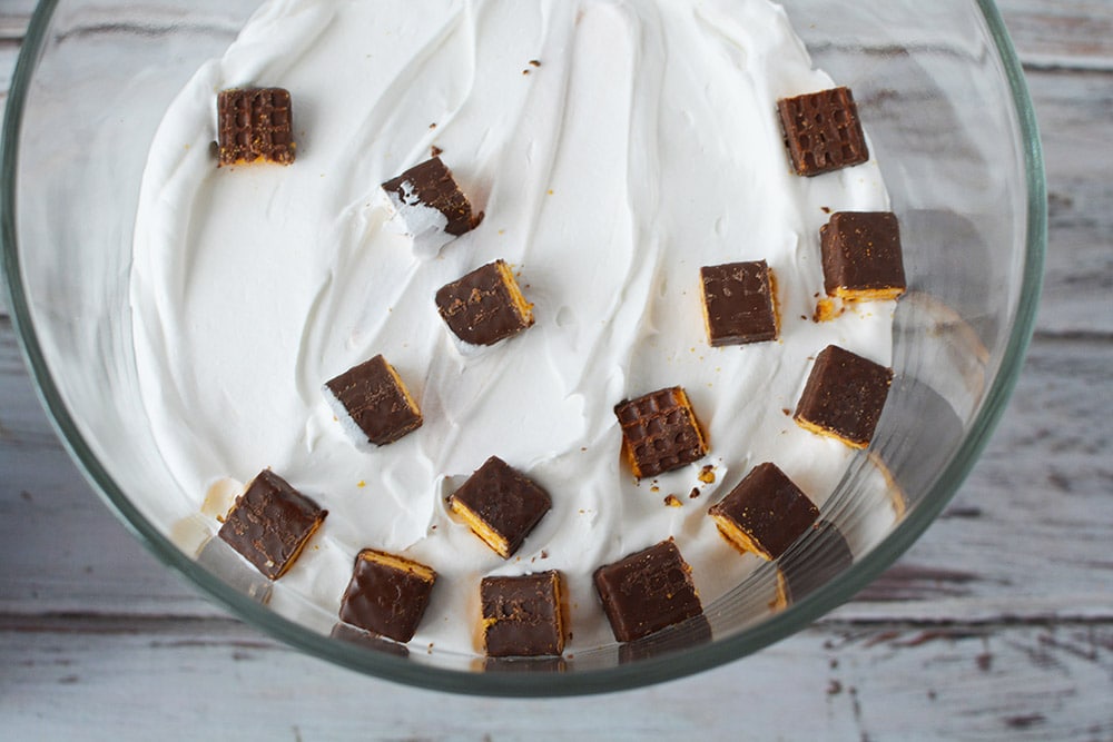 Pieces of fudge sticks on top of whipped cream in a trifle. 