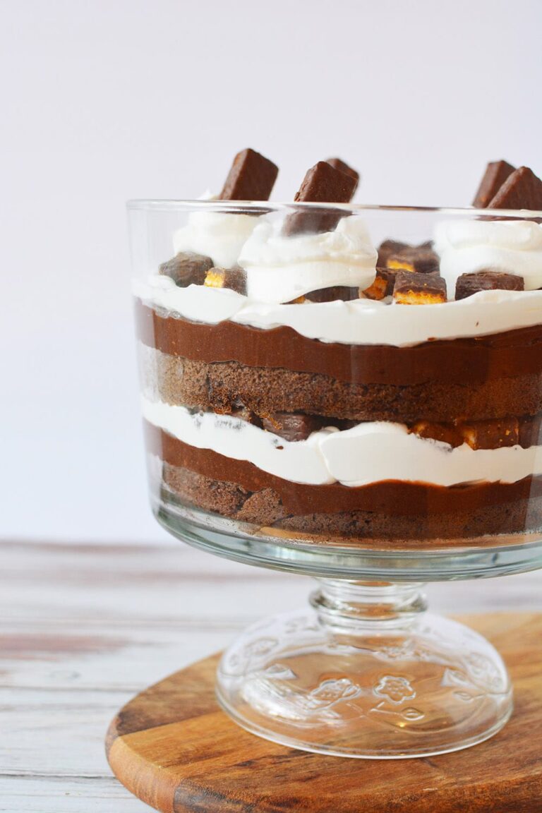chocolate trifle with layers of pudding, whipped cream, and cake in a bowl