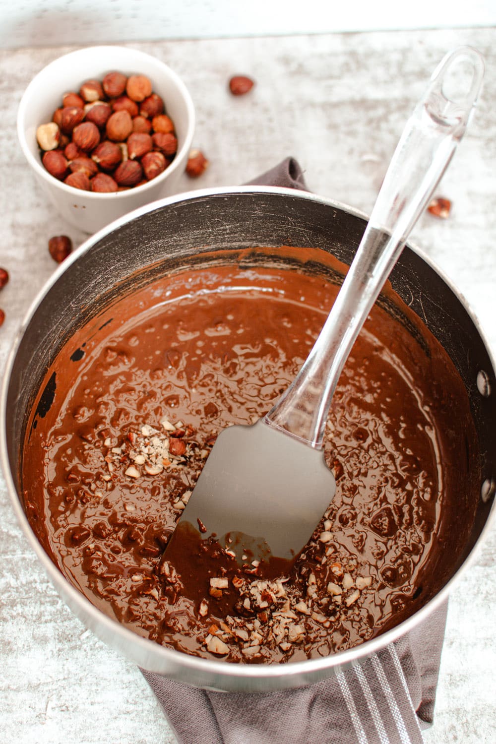 Stirring melted chocolate and coconut in a pan.