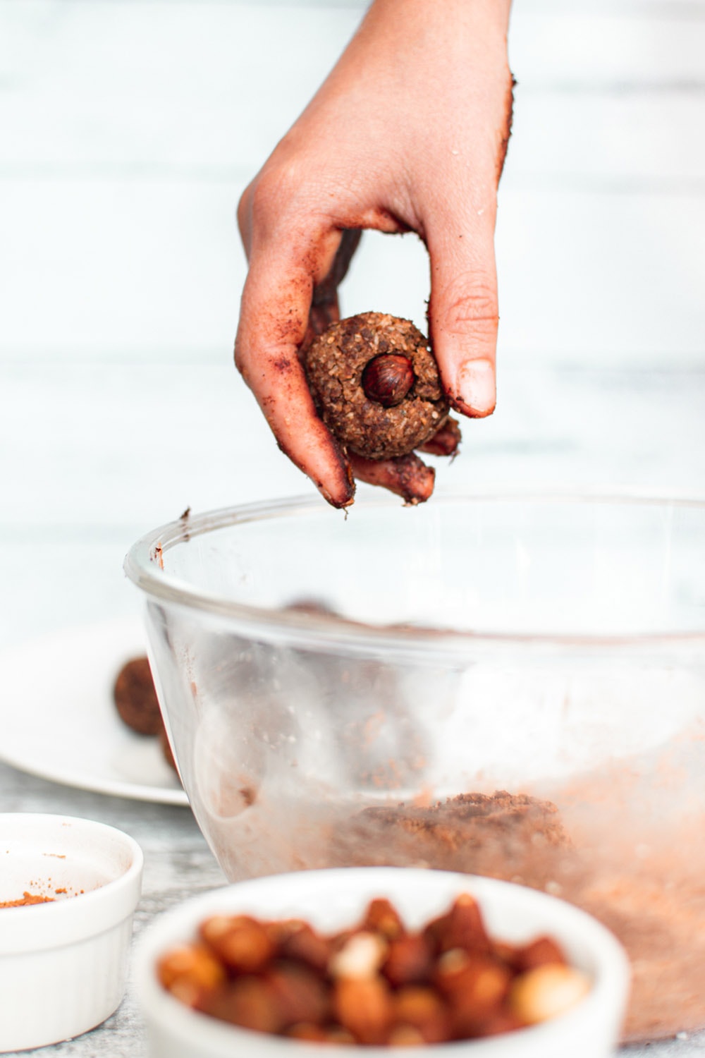 Rolling date balls and placing a hazelnut into the center.