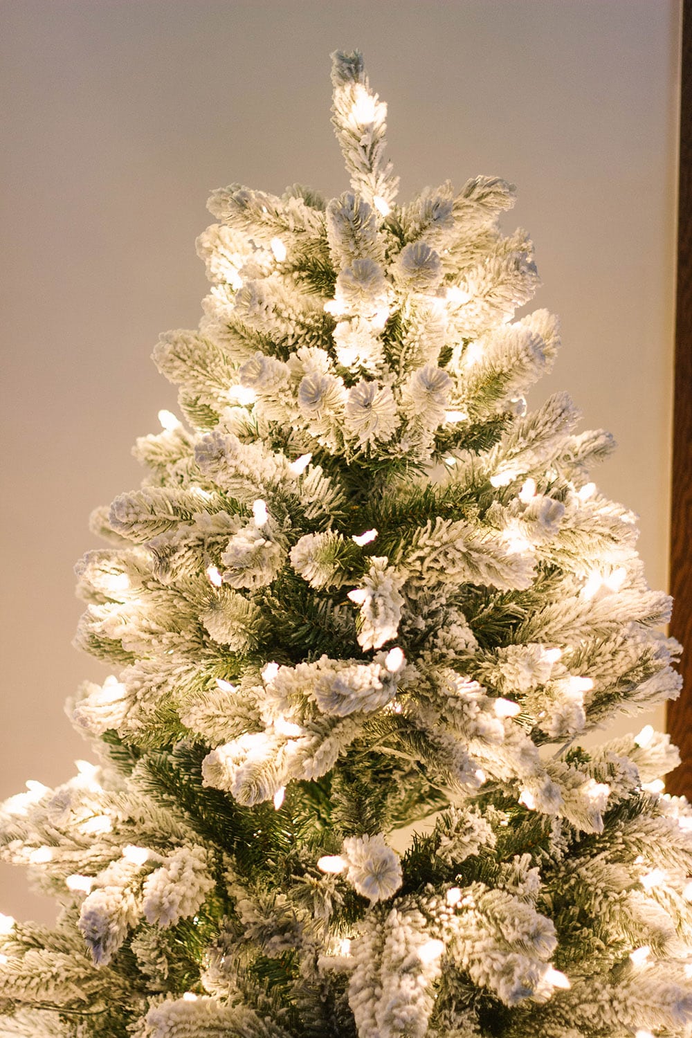 Flocked christmas tree lit up.