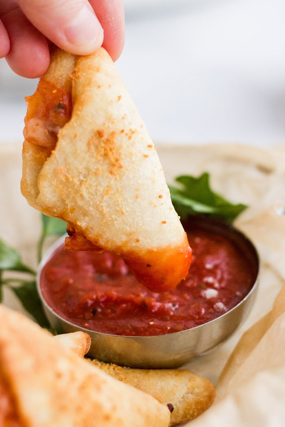 Dipping a pizza roll into marinara sauce.