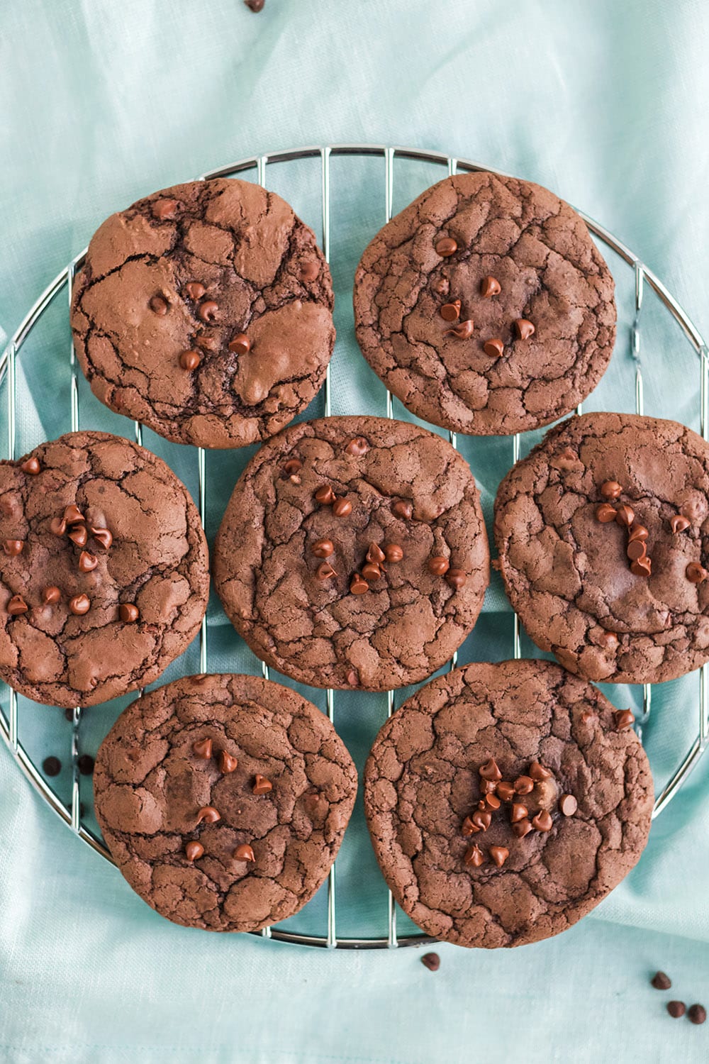 Brownie mix cookies on a rack on a blue towel.
