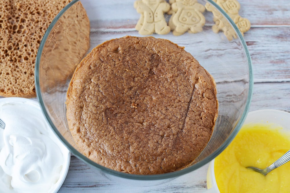 Spice cake round in the bottom of a trifle bowl. 
