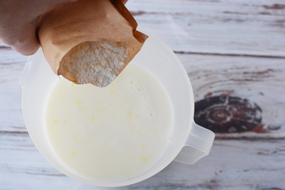 Pouring pudding mix into a container. 