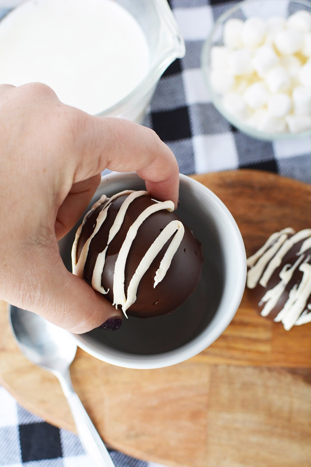 Dropping hot chocolate bomb into a mug.