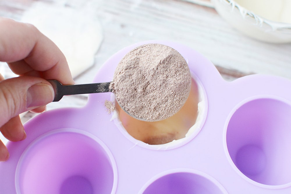 Adding hot chocolate mix into candy mold.