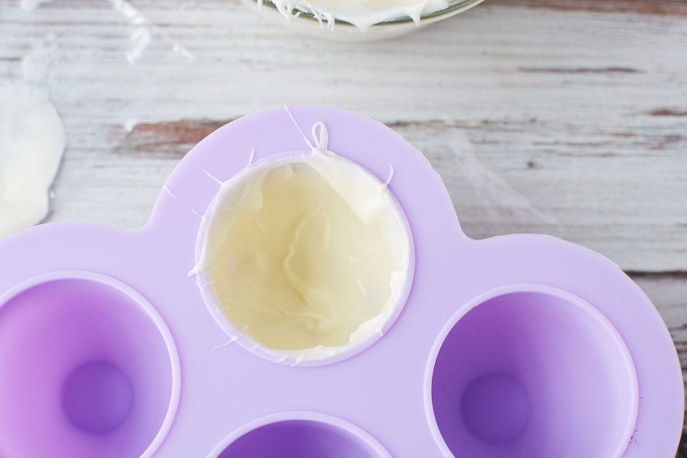 Lining a hot chocolate bomb mold with white chocolate. 