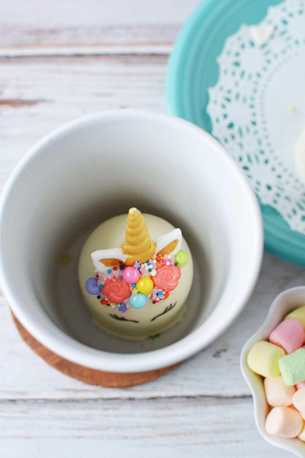Unicorn hot chocolate bomb inside of mug.