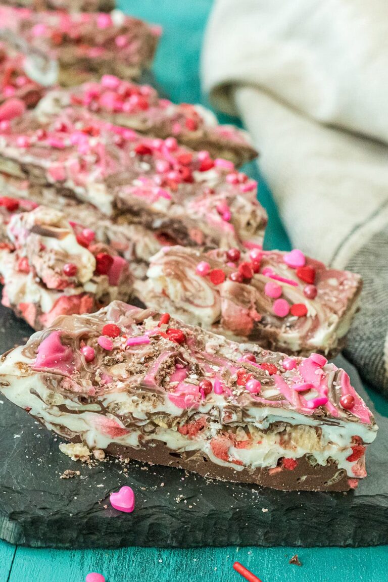 Strawberry crispy bark candy lined up on a board.