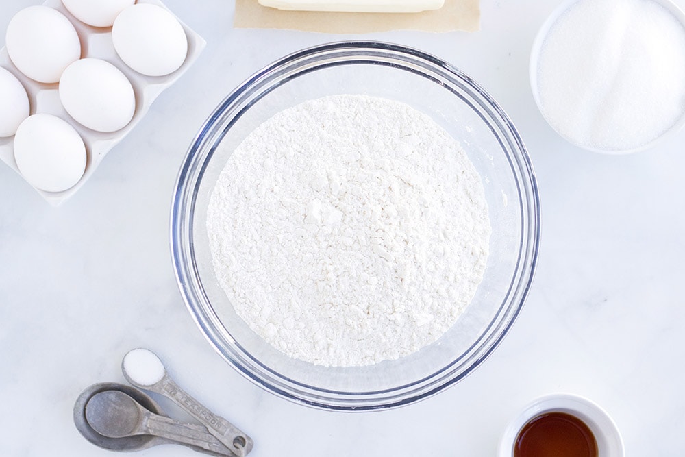 Bowl of sugar, eggs, and other sugar cookie ingredients.